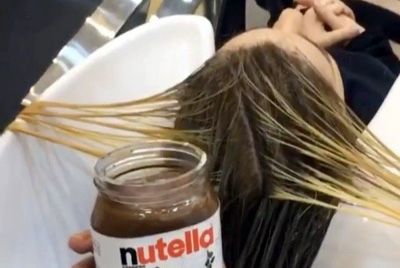 Стилист использует орехово-шоколадную пасту для покраски волос
