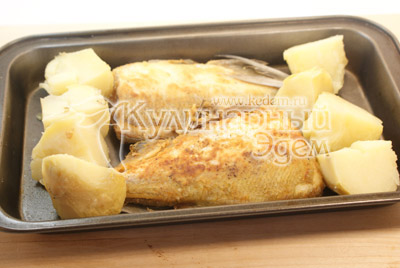 Обвалять в муке и обжарить на подсолнечном масле до полу готовности. Картофель отварить в подсоленной воде. Выложить на противень рыбу и картофель. 