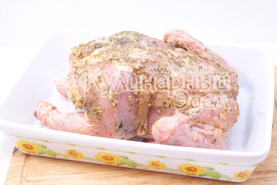 Специи, раздавленный чеснок и масло смешать в миске. Курицу натереть солью снаружи и внутри, а потом натереть смесью специй. Дать постоять 2 часа