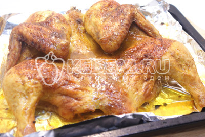 Поставить в духовку на 1 час при температуре 200 градусов С. Готовую курицу немного остудить и разрезать на половинки