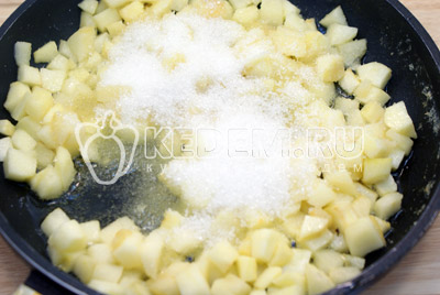 На сковороде разогреть сливочное масло, добавить яблоки и сахар. Хорошо перемешать и готовить под крышкой 7 минут на среднем огне