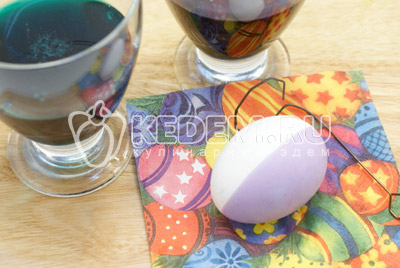 Краски развести по инструкции c уксусом. При помощи держателя опускать яйцо в краску на половину и держать 1-2 минуты. Выложить на салфетку и обсушить