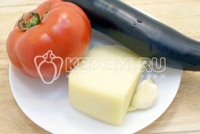 Помидор и баклажан вымыть, чеснок очистить, сыр натереть на терке. - Баклажаны с помидорами, запеченные под сыром. Фото рецепт приготовление баклажанов с помидорами.