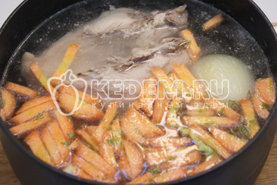 В кастрюлю добавить картофель и морковь, лук убрать. Варить 3-5 минут. 