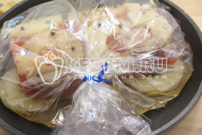 Выложить мясо с ананасами в пакет для запекания. Залить 100 -120 миллилитров сиропа от ананасов. Закрыть плотно пакет и выложить в форму.