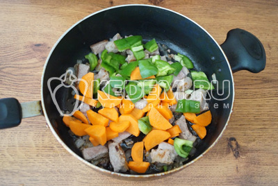 Добавить морковь и перец в сковороду и готовить 5-7 минут. До готовности мяса и моркови