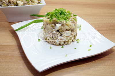 Выложить салат в салатницу или на блюдо при помощи сервировочного кольца. Украсить нашинкованным зеленым луком.