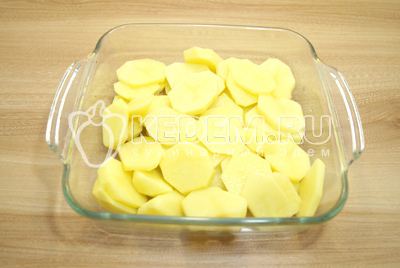 Картофель очистить. Нарезать картофель кружочками и выложить в форму смазанную растительным маслом. Немного посолить.