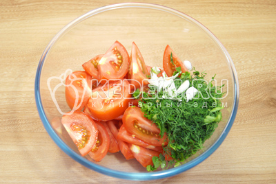В миску с помидорами добавить зелень и чеснок.