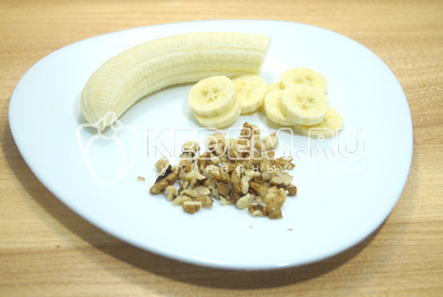 Разложить кашу по тарелкам. По желанию можно добавить банан и грецкие орехи. Для этого банан очистить и нарезать кружочками, орехи немного измельчить.