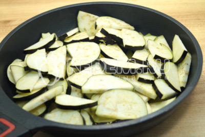 Нарезать полукольцами баклажаны и обжарить на растительном масле на сковороде, 12-15  минут помешивая.