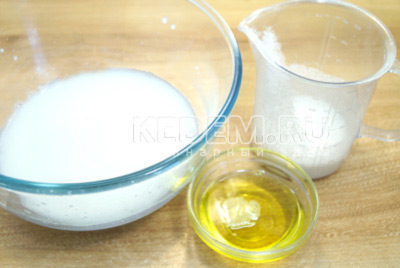 В миску влить теплое молоко, добавить растительное масло и сахар.