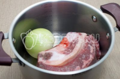В кастрюлю сложить мясо с луком и залить 2,5 литра воды.