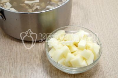 2 картофелины очистить и нарезать кубиками, добавить в кастрюлю, варить еще 10 минут.