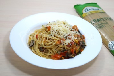 Выложить спагетти с соусом на тарелки и посыпать тертым сыром пармезан.