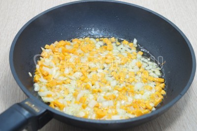 Обжарить мелко нашинкованный лук и кубиками нарезанную морковь 2-3 минуты.