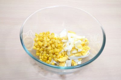 В большую миску нарезать соломкой отварные яйца и добавить 100 грамм консервированной кукурузы.