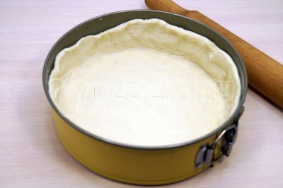 Выложить тесто в форму для выпечки с высоким бортом смазанную сливочным маслом. Сформировать глубокие бортики.