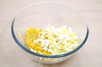 В миске смешать 100 грамм консервированной кукурузы и 3 отварных яйца нарезанных кубиками.