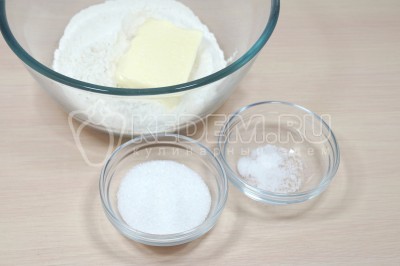 Добавить в миску к муке 120 грамм мягкого сливочного масла, 3 столовые ложки сахара и 1 щепотку соли.