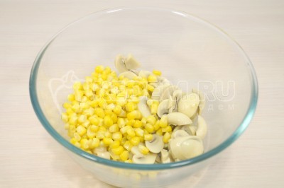 В большую миску выложить грибы. Добавить 200 грамм консервированной кукурузы.