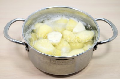 Сложить картофель в кастрюлю. Залить водой и поставить вариться. Добавить 1/4 чайной ложки соли. Варить 30-40 минут до готовности картофеля.