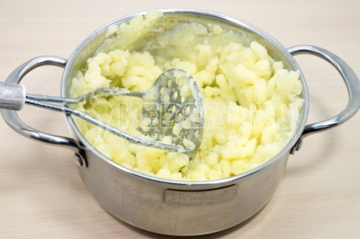 Потолочь картофель толкушкой в пюре.