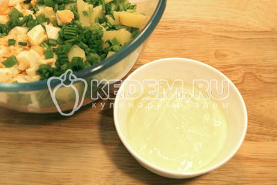 Добавить в миску с салатом мелко нарубленный зеленый луки заправку.