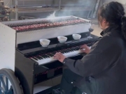 Музыкант виртуозно играет на пианино, на котором готовится шашлык