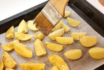 В отдельной миске смешайте масло, раздавленный чеснок,зелень,соль, перец. Смесью обмажьте каждый ломтик картофеля