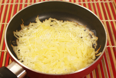 Сыр потереть на крупной терке и выложить слоем в сухую сковороду и нагреть на среднем огне