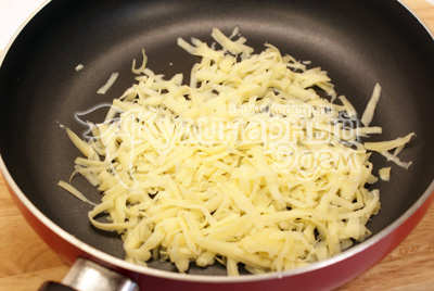 Сыр натереть на терке и растопить на сухой сковороде