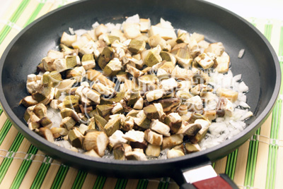 Мелко нашинкованную луковицу обжарить на растительном масле, добавить грибы. Обжаривать 3-5 минут. 