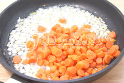 На сковороде с растительным маслом обжарить мелко нашинкованный лук и колечками нарезанную морковь, обжаривать 3-5 минут