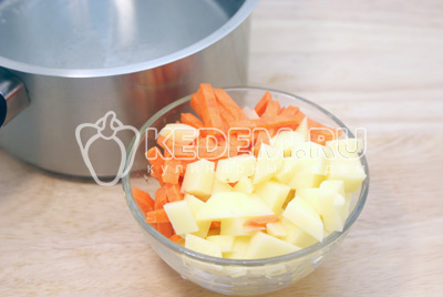 Картофель и морковь очистить и порезать кубиками или брусочками. Воду вскипятить. Добавить в кастрюлю с водой картофель с морковью. Варить до полуготовности