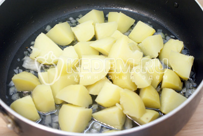 Добавить четвертинками порезанный картофель и обжаривать до золотистой корочки