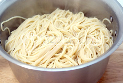 Спагетти отварить до готовности в подсоленной воде с добавление пары столовых ложек растительного масла. Откинуть на дуршлаг и дать воде стечь. Переложить в кастрюлю и оставить в теплом месте