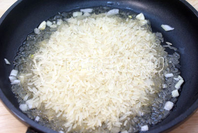 Для гарнира обжарить рис с мелко нашинкованным луком на сковороде с растительным маслом, примерно 2-3 минуты