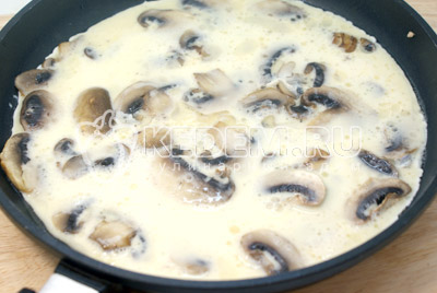 Сковороду с грибами снять с огня, залить грибы яичной смесью