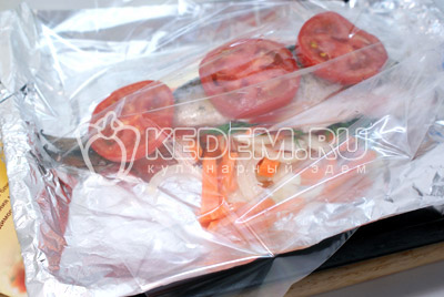 Выложить лук и морковь в пакет для запекания, немного посолить и поперчить. Сбрызнуть маслом. Уложить поверх овощей рыбу и накрыть помидорами. Полить остатками масла и закрыть пакет. Готовить в духовке 20-25 минут при температуре 200 градусов С.
