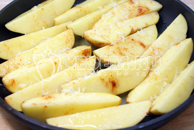 Картофельные дольки выложить в один слои, в форму или на противень. Полить сливочный-чесночным маслом