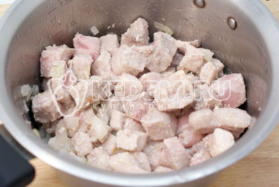 Добавить кусочками порезанное мясо и обжаривать до полуготовности