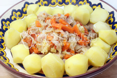 Выложить в середину глубокого блюда мясо с овощами, при помощи шумовки, а по краям картофель. Полить бульоном от мяса