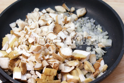 Нарезать кубиками грибы и лук. Обжаривать на растительном масле 5-7 минут. Посолить и поперчить