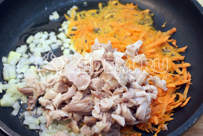 На растительном масле обжарить мелко нашинкованный лук и тертую морковь, добавить мясо курицы без костей. Готовить 1-2 минуты. Добавить в бульон