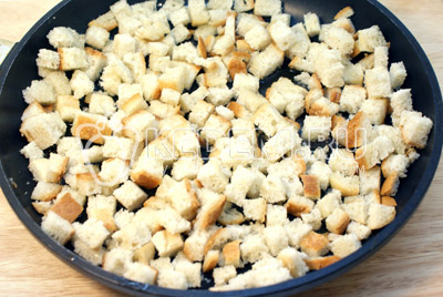 Хлебные кубики посыпать солью и сбрызнуть чесночным маслом