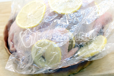 Остальными ломтики лимона обложить курицу и завязать пакет зажимом