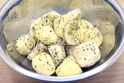 Картофель очистить и нарезать половинками. Посолить и приправить сухими травами. Из противня взять 2-3 ст. ложки вытопившегося жира и добавить в картофель. 