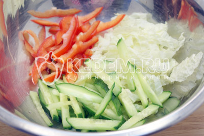 Для салата нашинковать пекинскую капусту, соломкой нарезать огурец и перец. Перемешать в миске. Заправить оливковым маслом и посолить