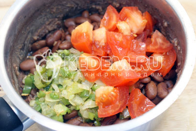 Добавить в вторую половину фасоли пережаренные овощи и кубиками нарезанный помидор. Посолить и поперчить